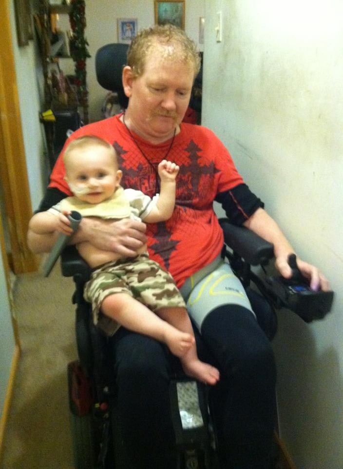 Papa giving Eli a ride on the wheelchair