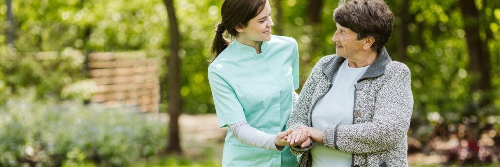 Nurse and patient in the garden of modern senior home with daily care